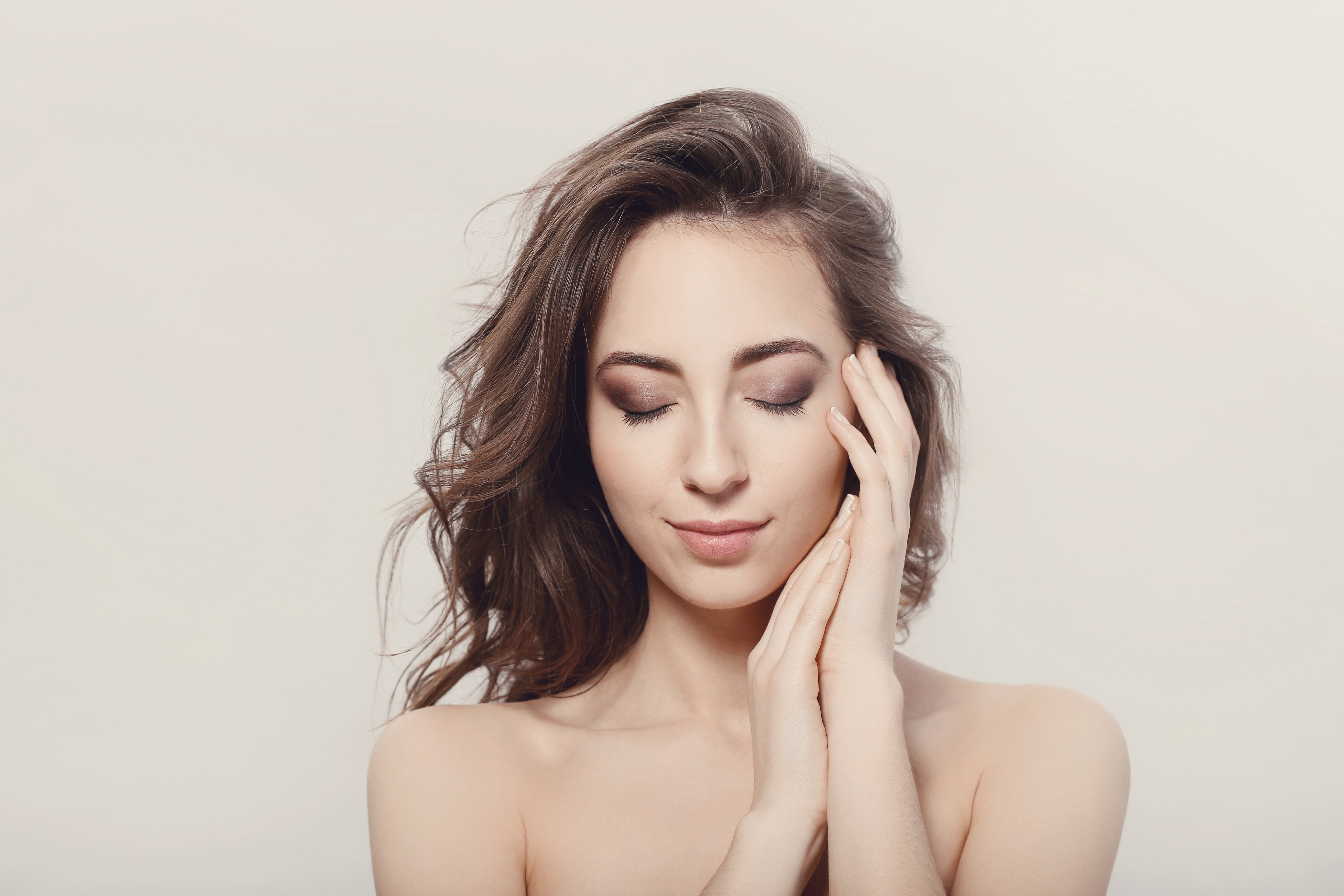 a pretty young woman touching her face