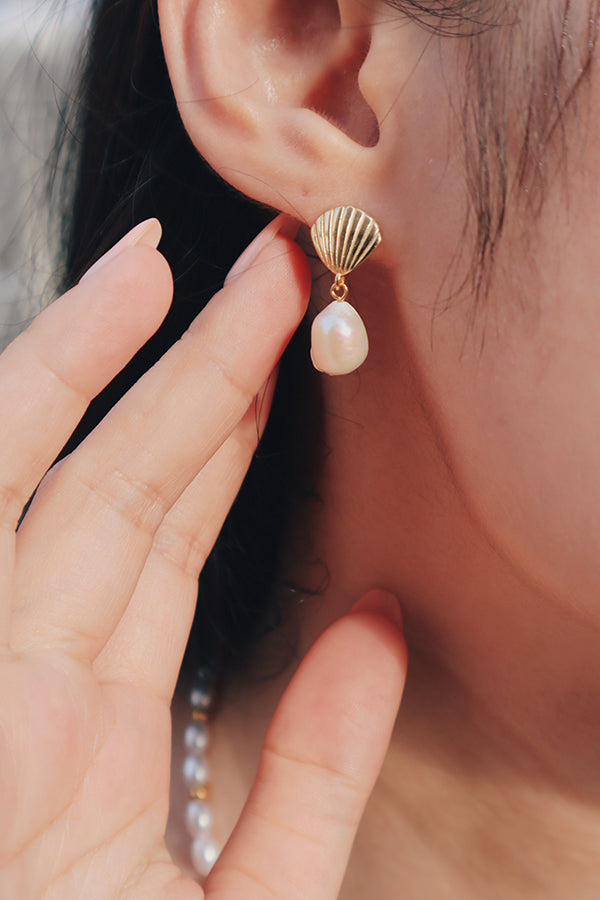 Woman showing her summer vibes vacation earring to the camera.