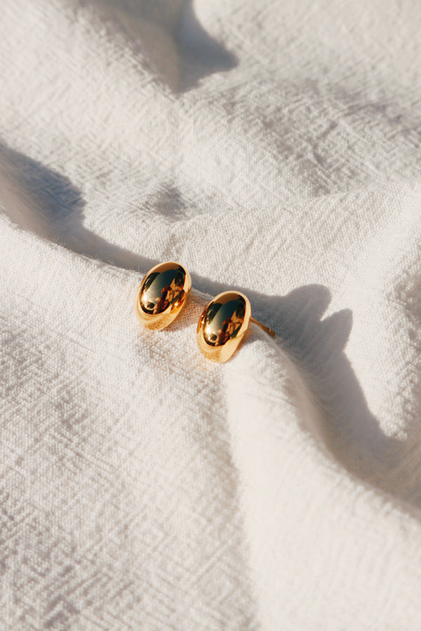 A pair of stunning gold studs shining under the sun.