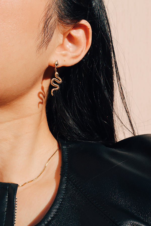 女生模特兒配戴宣言飾品蛇形金色耳環顯得率性獨特