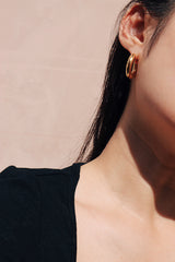 Asian girl in black showing her hoops on one side under the sun