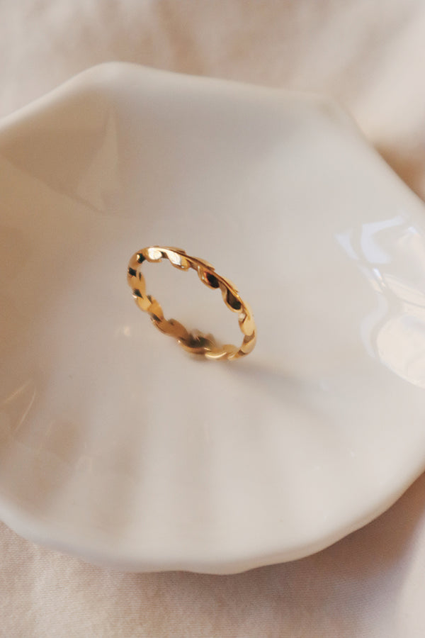 A dainty gold laurel ring in the white plate.