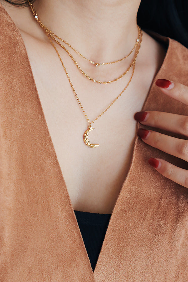 Black hair woman layering three different necklaces for her winter oufit