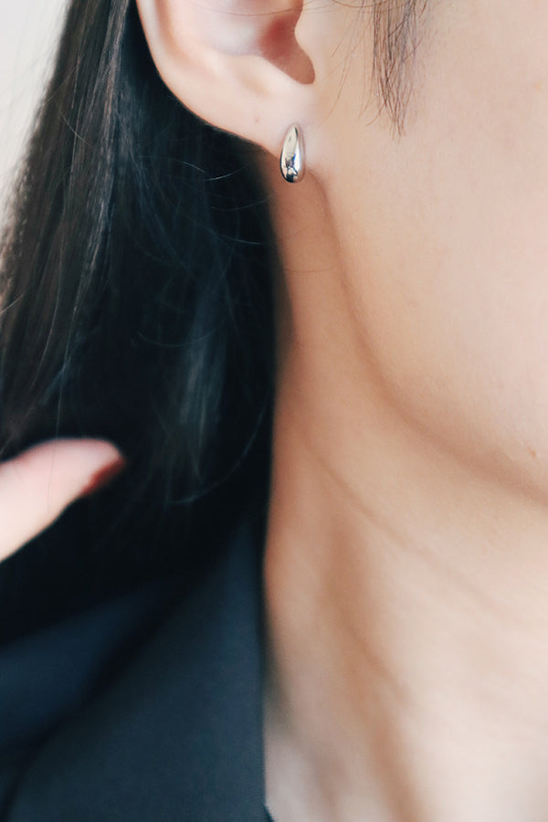 Asian girl in black suit wearing silver earrings.
