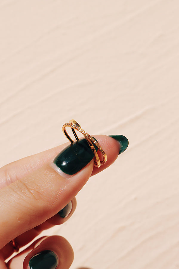 Close-up of a delicate gold ring with cubic zirconia cross design, ideal for chic and sophisticated jewelry styling.