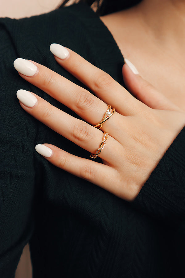 A woman's hand styled with a delicate gold twisted ring, perfect for stacking with other dainty jewelry.