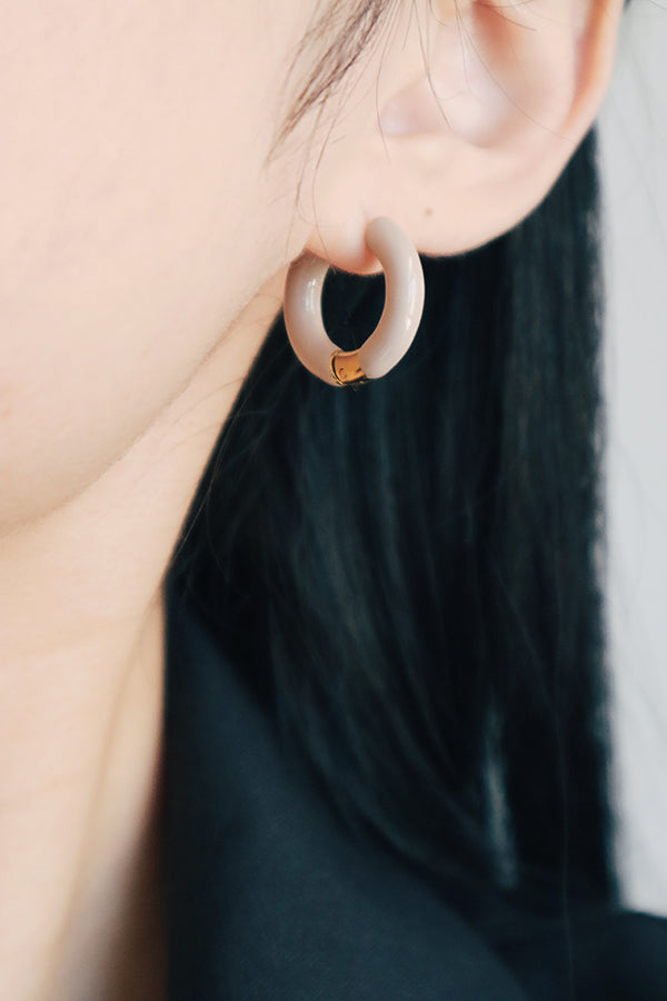 Elegant woman selected a pair of gray hoops for her winter ootd.