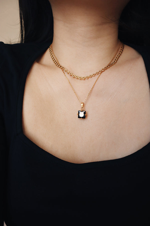 時髦的女生用兩條項鍊疊戴出優雅時尚的穿搭風格。