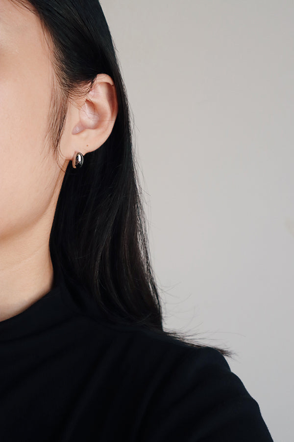 女孩佩戴著精緻好看的簡約時髦銀色耳環。