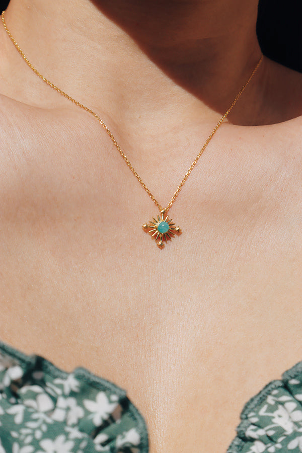 Woman wearing a green floral dress paired with a starburst amazonite necklace, radiating a romantic natural vibe.