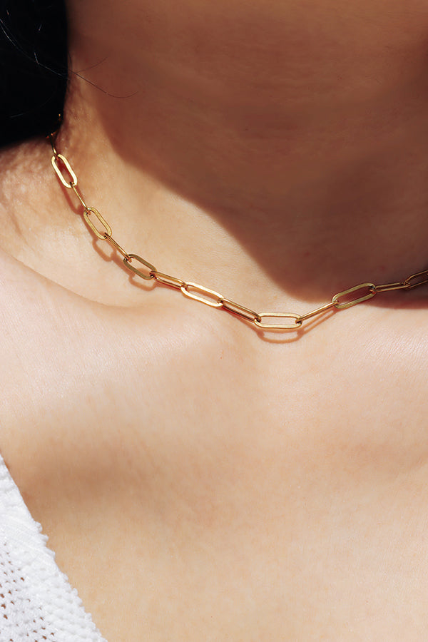 Detailed view of elongated links on a gold paperclip chain necklace with a structured modern design.
