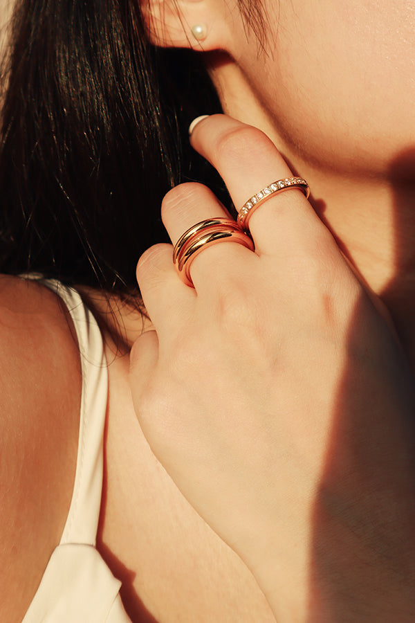 模特兒展示抗敏感的疊戴戒指三件組,兩枚簡約戒指與一枚閃耀鋯石戒指疊加,營造出多層次的優雅風格。