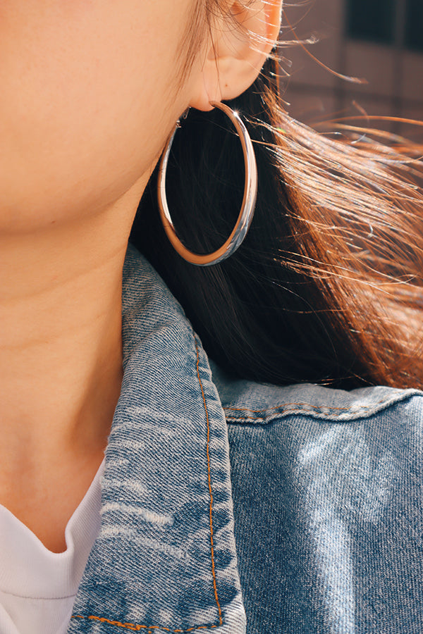 Large stainless steel hoop earrings paired with a relaxed outfit for a stylish and effortless aesthetic.