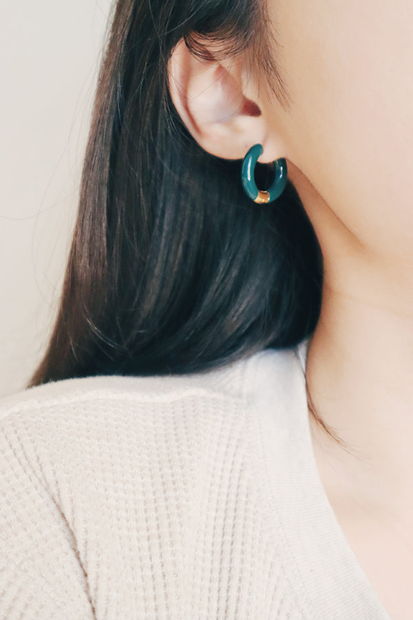 Woman-wearing-quality-luxurious-dark-green-hoops.