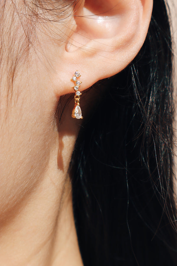 Woman wearing mini teardrop crystal earrings add a subtle touch of sophistication to everyday styling, ideal for chic commuter looks.