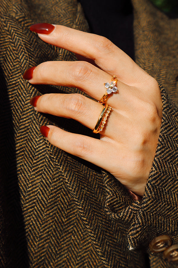 Slim gold zircon ring styled with a tailored coat, offering effortless everyday elegance.