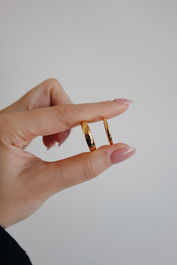 Model holding two types of gold rings.