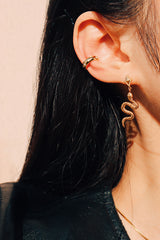 女性以金色蛇形個性耳環搭配星光耳骨夾打造率性時髦感