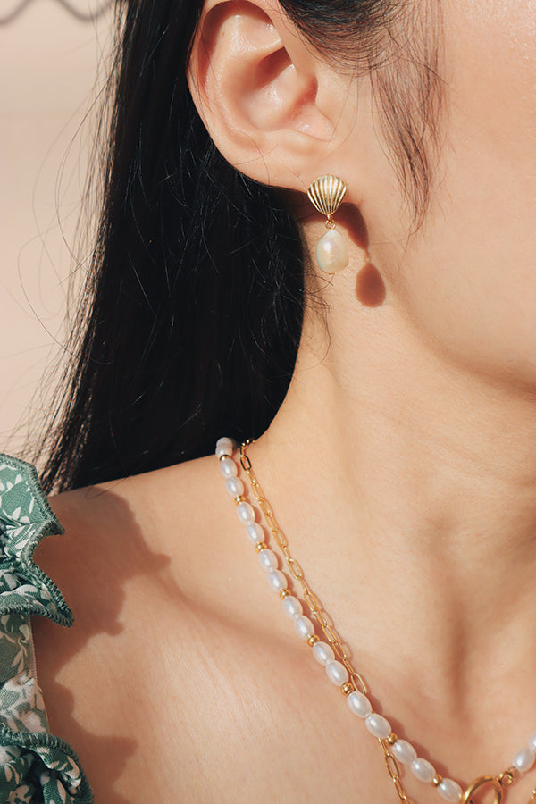 Woman wearing Kyra Pearl Drop Earrings for a summer essential with ocean vibes.