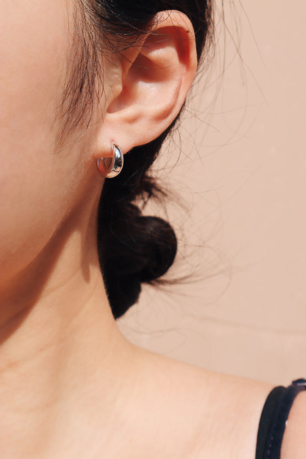 鏡頭近距離拍攝女生配戴在左耳的抗敏感純銀圈圈耳環細節