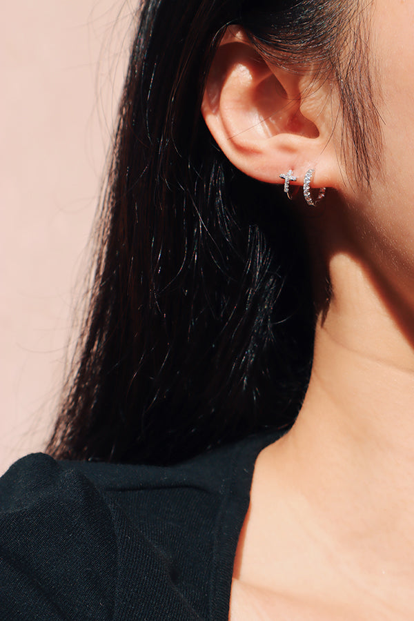 Model stacks silver huggies to elevate her style.