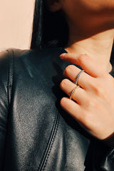 穿黑皮衣外套的女性以金色銀色扭紋戒指打造個性化的穿搭風格