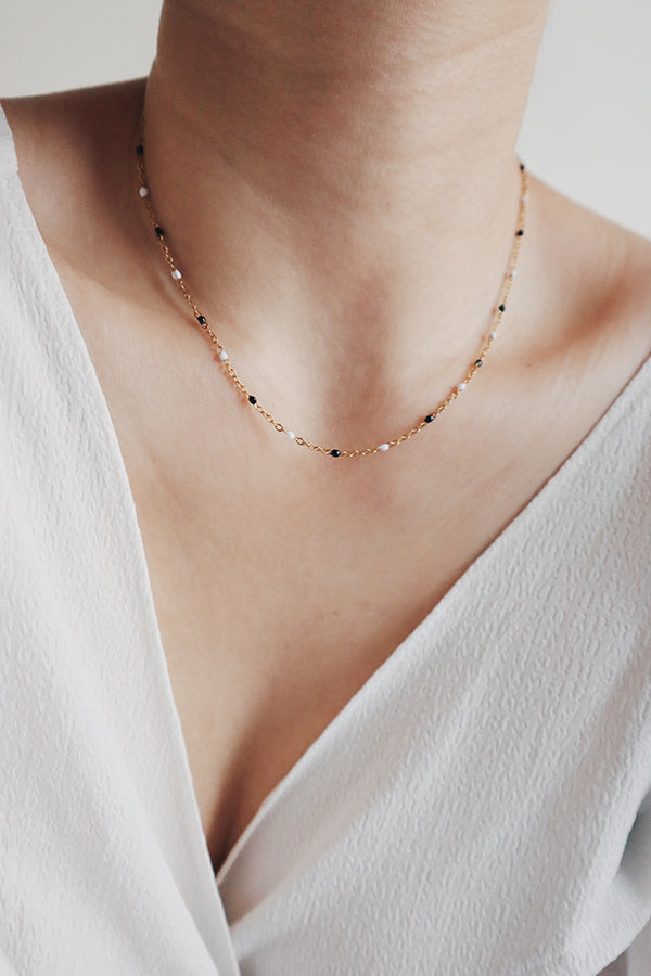 優雅女性配戴黑白滴油圓珠頸鏈。