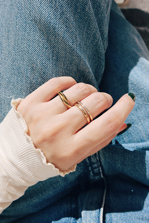 穿牛仔褲的女人展示著手上的雙層疊戴金戒,完美呈現別緻且日常的時尚造型。