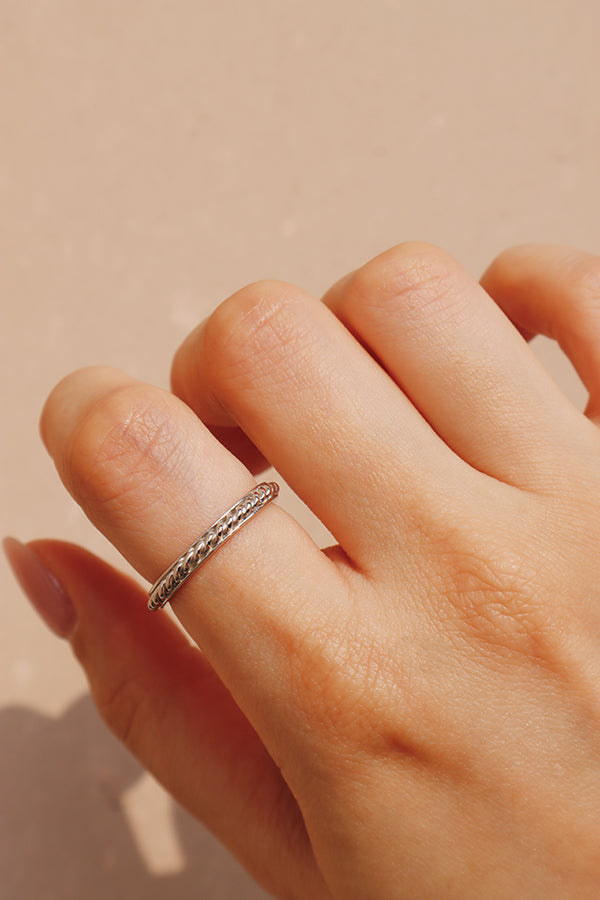 Woman wearing silver rop ring on her point finger.