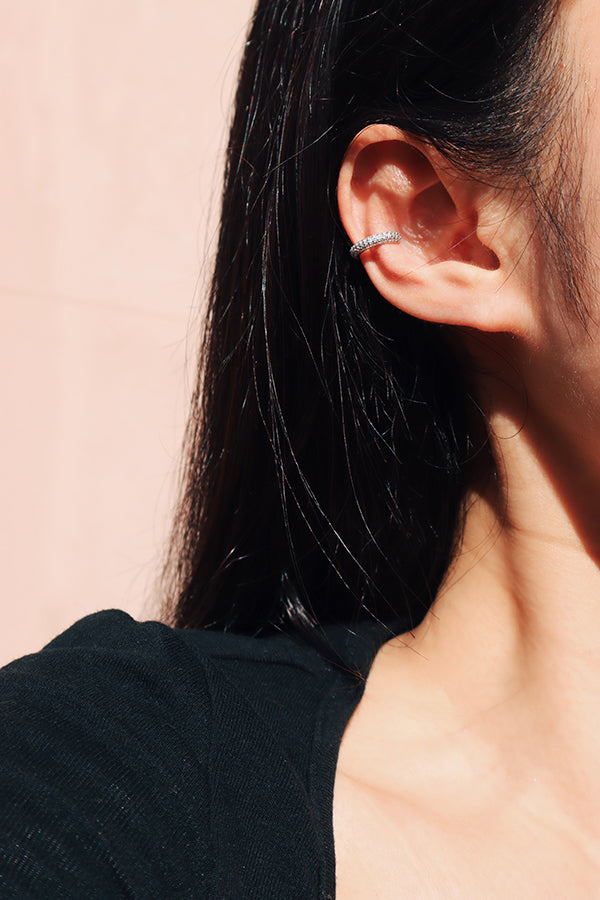 Black hair woman showing her half face that wearing sterling silver shiny ear cuff.