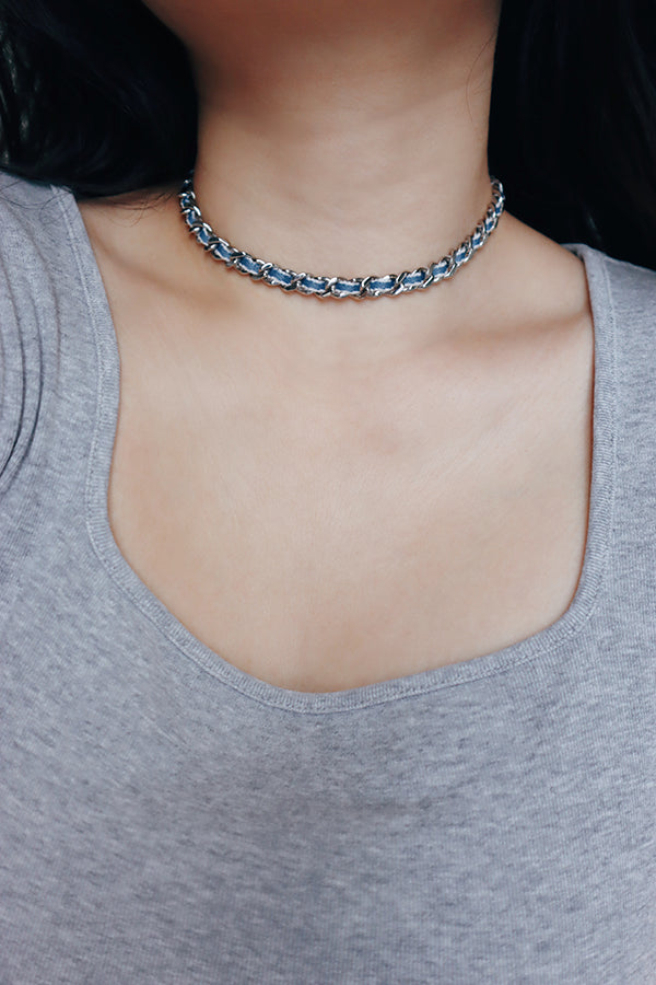 Urban silver denim necklace worn as a statement piece, adding personality to a simple outfit.