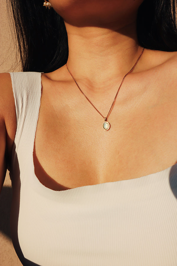 Woman wearing a water-resistant white jade pendant necklace with a clean minimalist design, perfect for both casual and formal occasions.