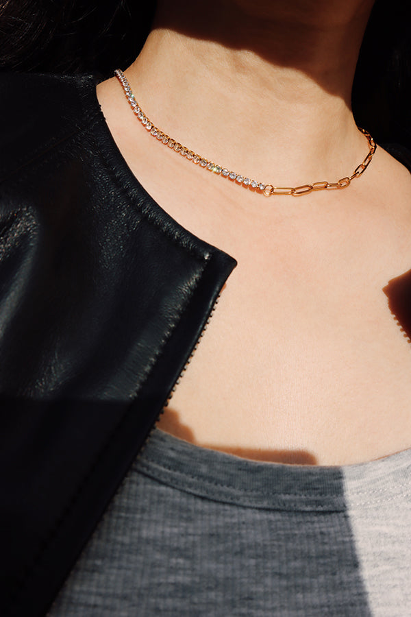 Half zircon tennis-style necklace catching natural light, paired with a gold chain for balanced shine.