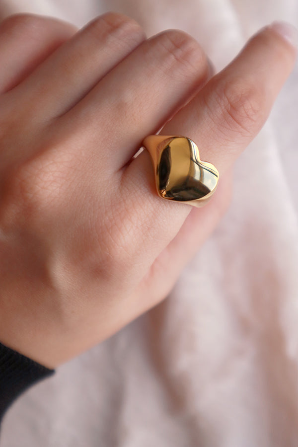 Model shows her hand wearing the heart shape gold ring to the camera