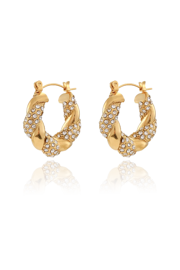 A pair of shiny gold twisted hoop earrings, heavily embellished with sparkling clear cubic zirconia stones, shown as a product shot without background.