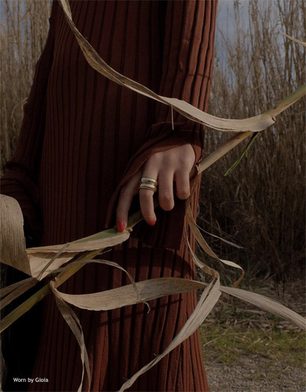 Red dressed model wearing stacked rings in bush