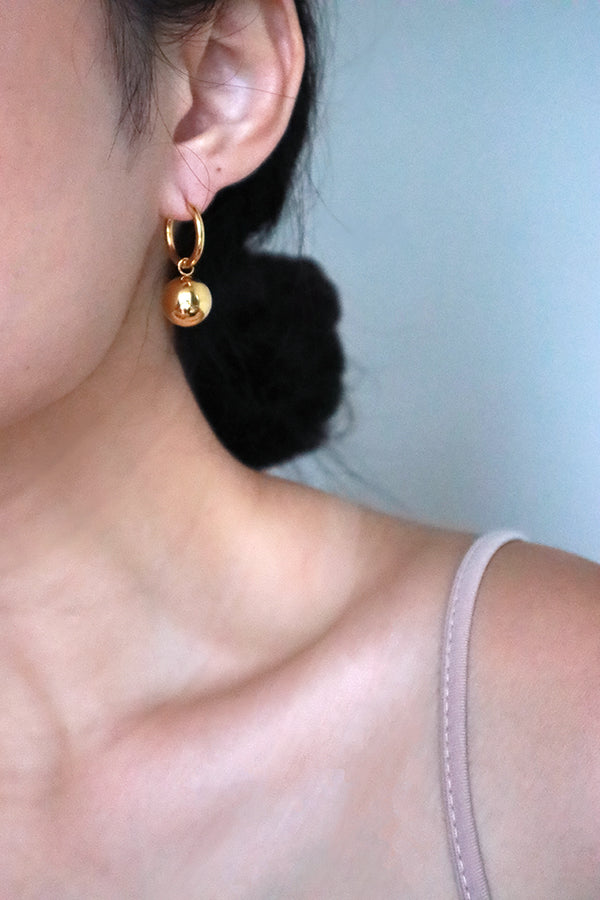 Model wearing tarnish free gold solid ball hoops