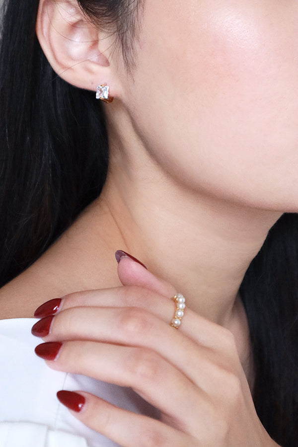 Asian model with red nails wearing shiny cz earrings showing her half face to camera