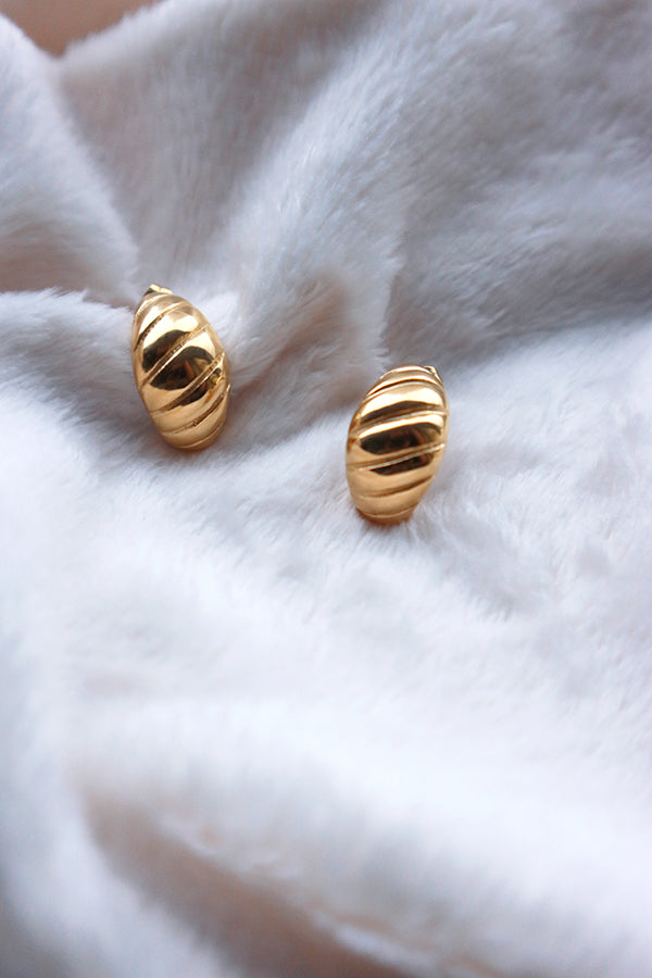 Popular croissant gold earrings on a white blanket