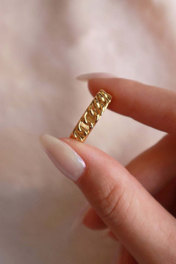 Woman holding a stainless steel gold ring for camera shooting.