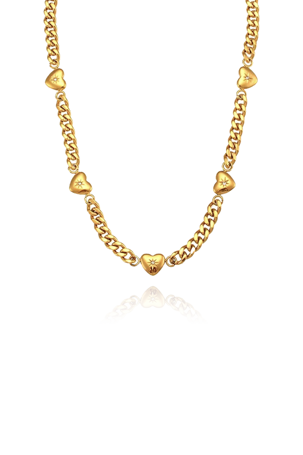 A gold Cuban link chain choker necklace, featuring heart-shaped charms with starburst engravings and small clear gems, shown as a product shot without background.