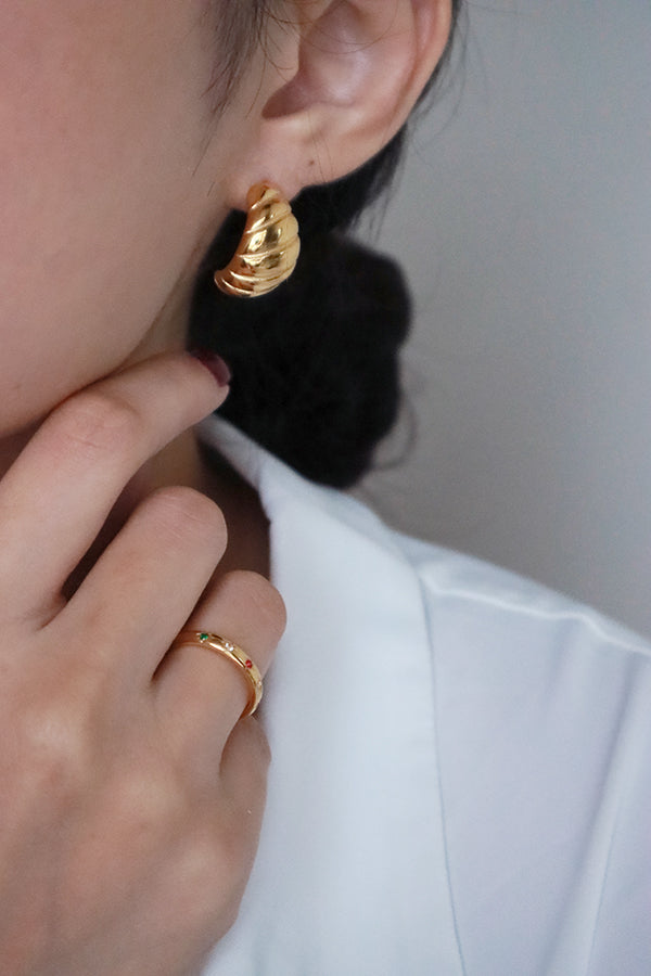 Model in white shirt wearing trendy croissant gold earrings