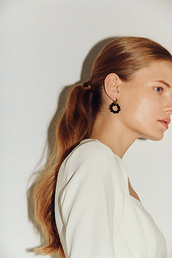 Side shot of girl with black onyx circle earrings