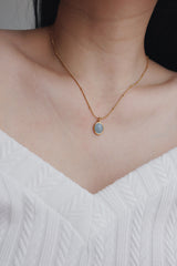 Woman in white dress wearing gold plated necklaces