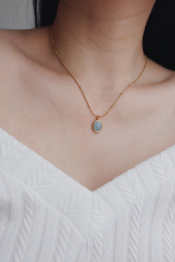 Woman in white dress wearing gold plated necklaces