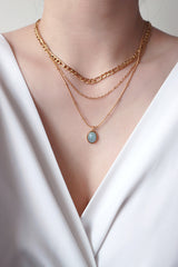 Model layering aquamarine necklace with Figaro layered necklace