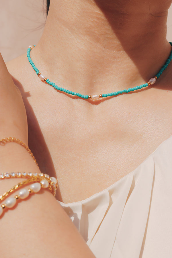 Fashion-forward woman showcasing a boho bead and freshwater pearl choker for bohemian-style summer look.