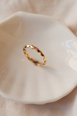 A dainty gold laurel ring in the white plate