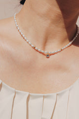 Woman wearing a dainty beautiful pearl choker perfect for layering summer outfits