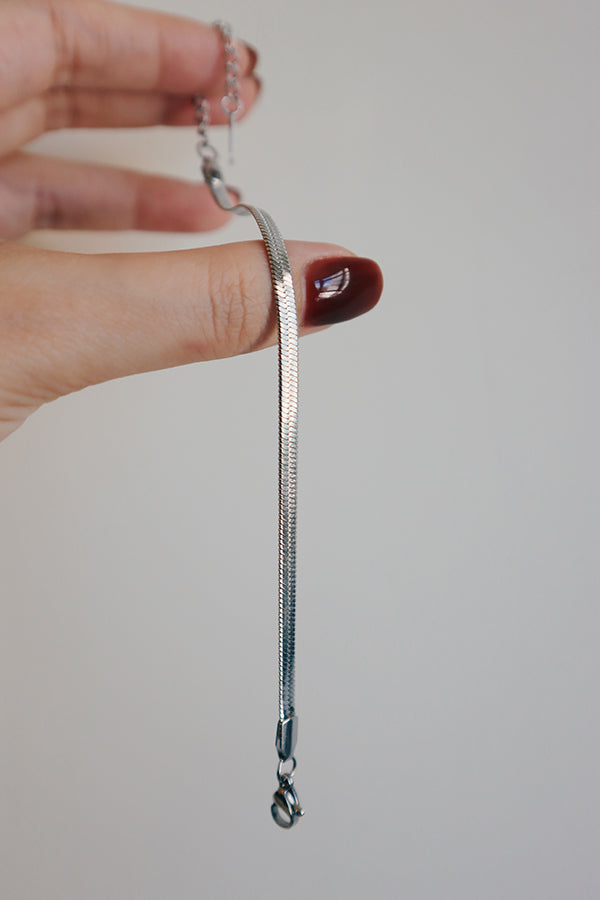 Woman showing details of silver bracelet to friends